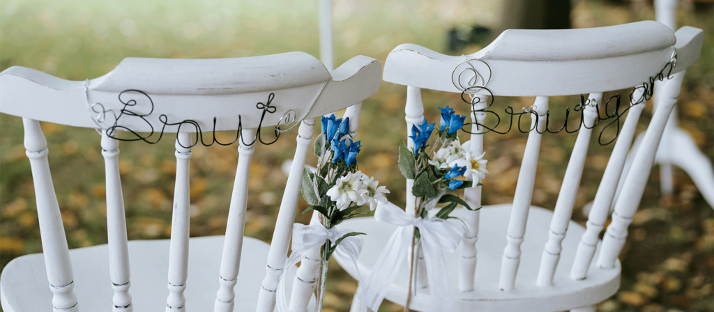 Zwei weisse Stühle mit Braut und Bräutigam für Hochzeiten